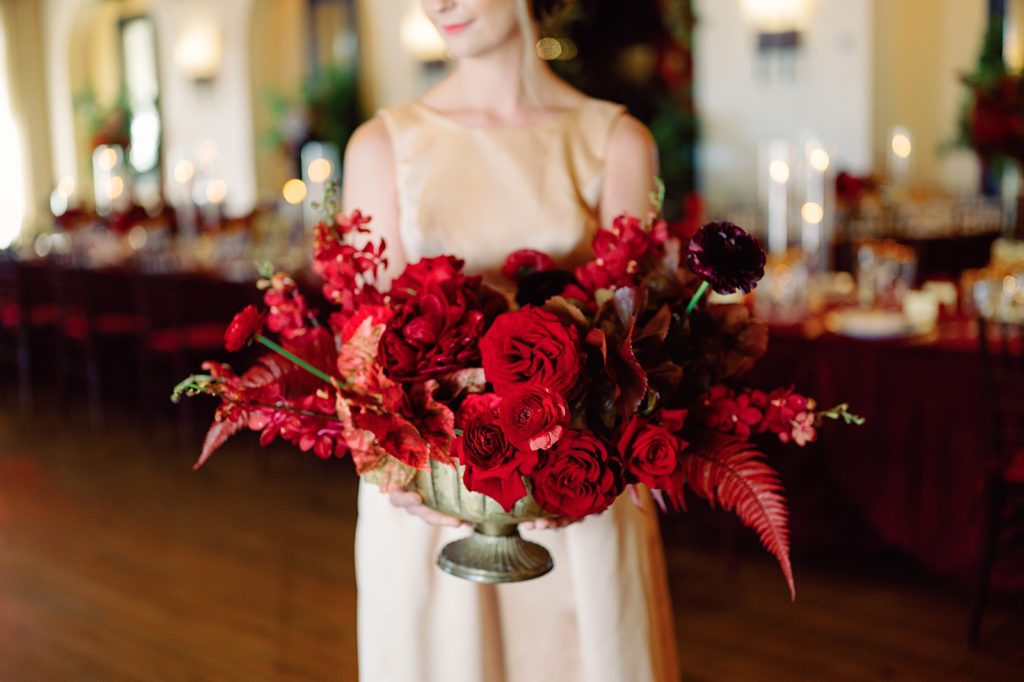 Bridesmaid holding red flower piece