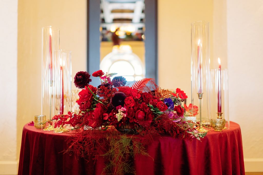 Red flower centerpiece on sweetheart table