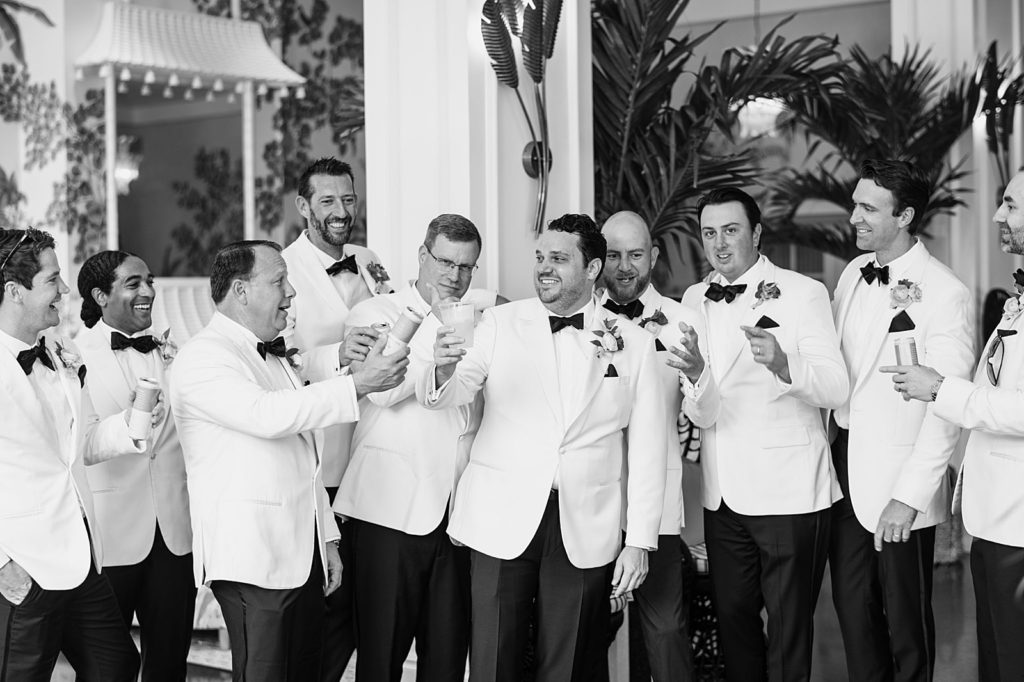 Groom with groomsmen cheering after getting ready B&W