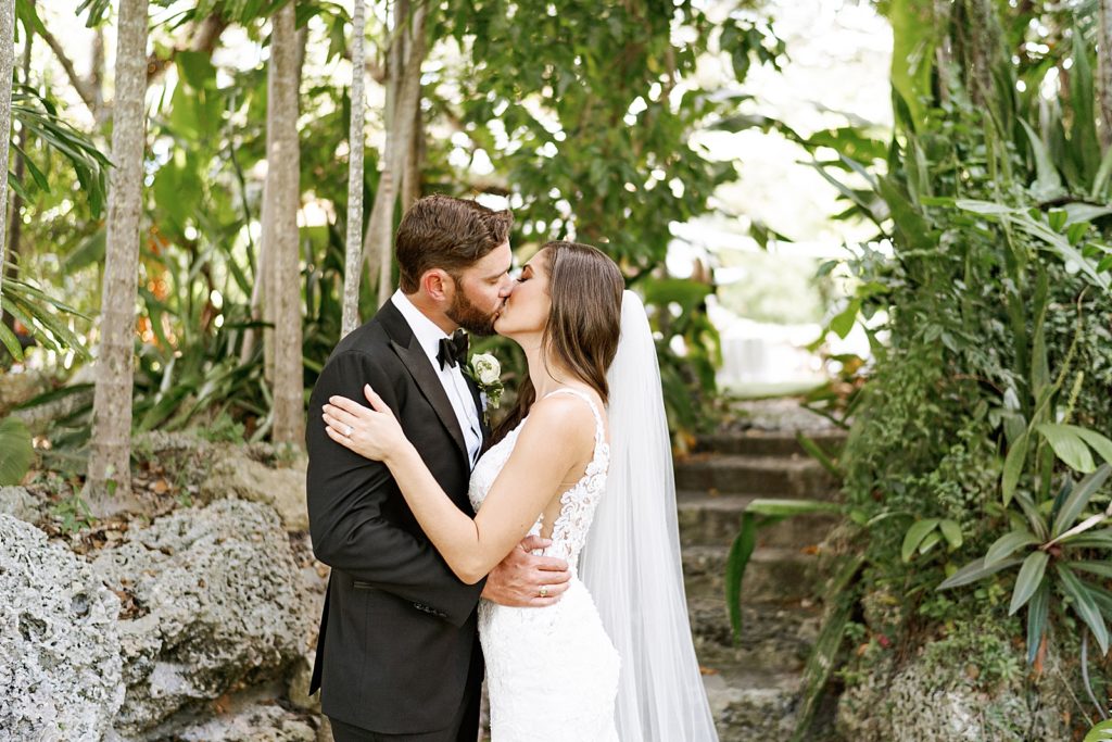 Bride and Groom kissing in green garden area