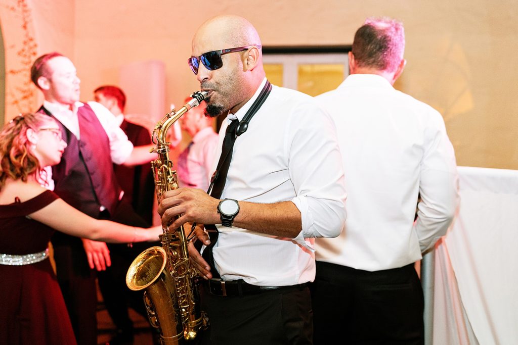 Candid shot of saxophone player playing at Reception