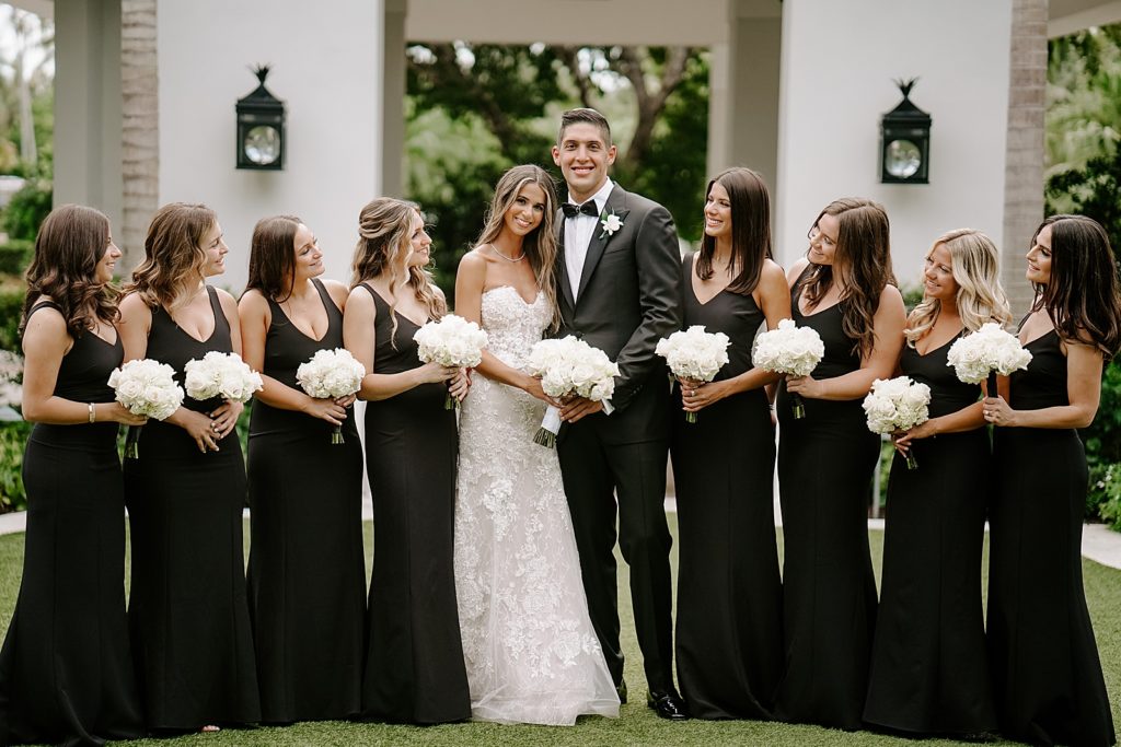 Bride and Groom holding each other with Bridesmaids watching holding white bouquets