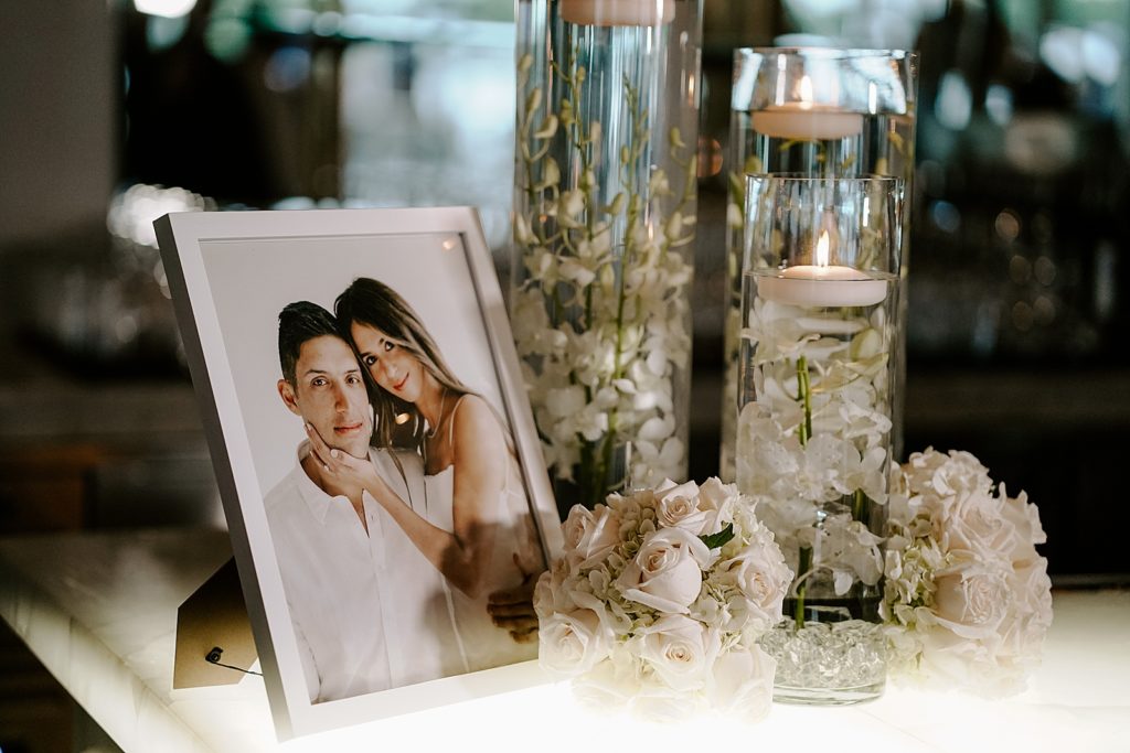 Detail shot of table with white flower decor and picture of Bride and Groom