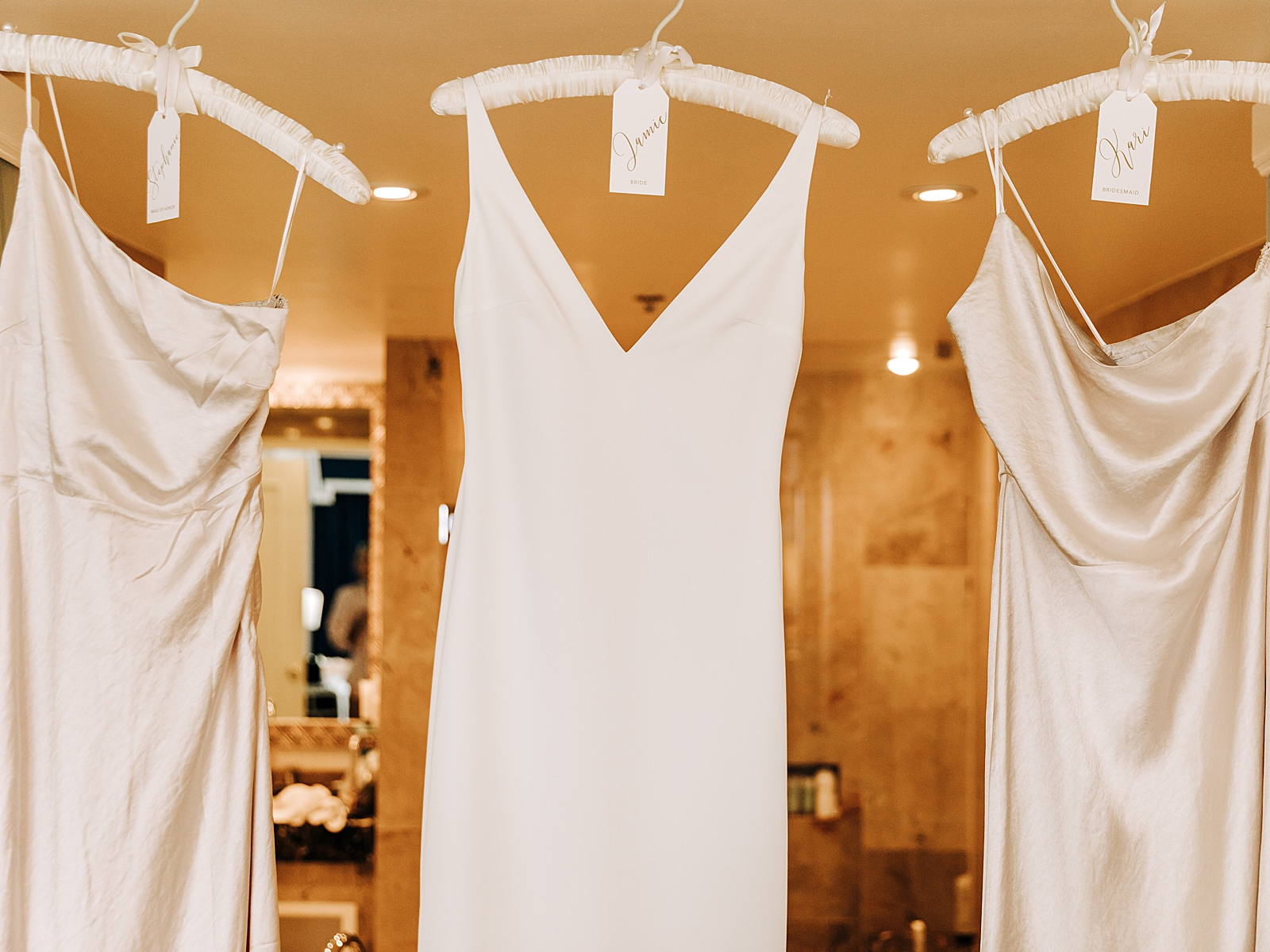 Wedding dress and Bridesmaid dresses hanging on coat hangers