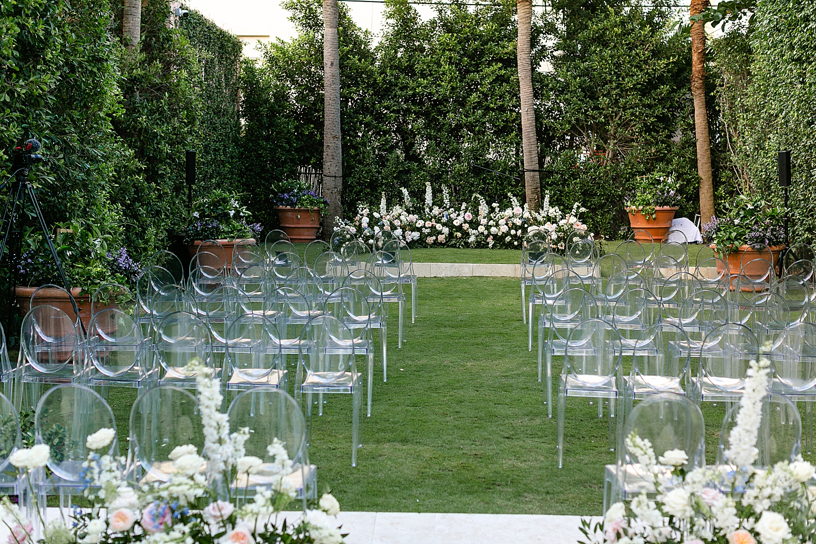 Wide detail shot of Ceremony area with transparent chairs and flowers