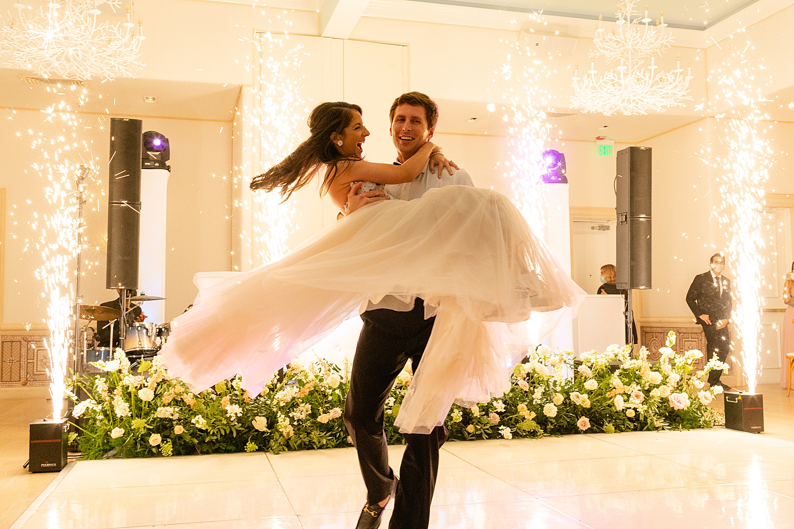 Groom carrying Bride in arms on dance floor