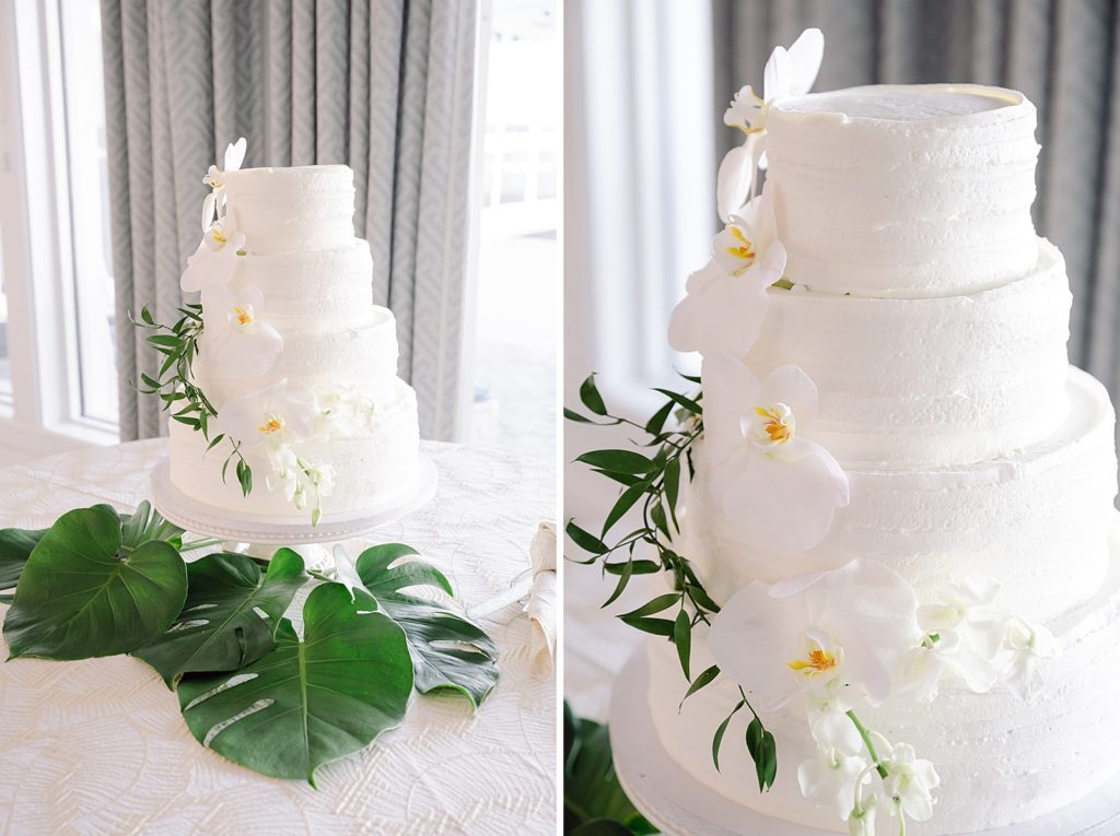 Detail shot of wedding cake with white floral decor and palm leafs around it