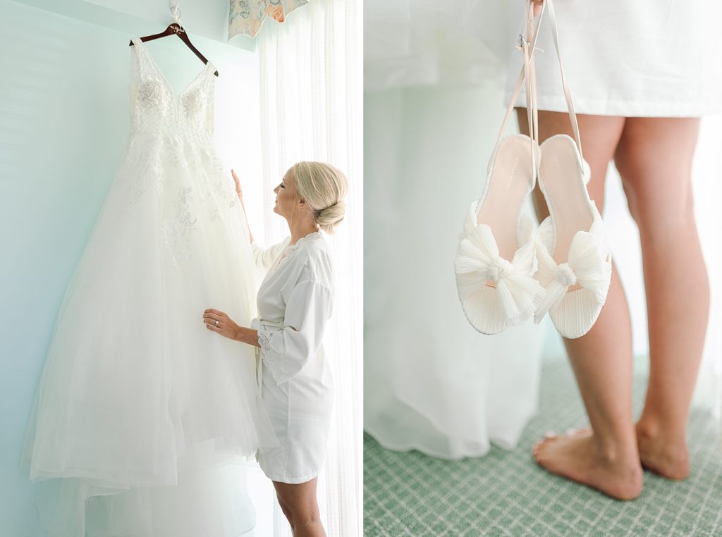 Bride looking at dress hanging off wall and holding wedding shoes