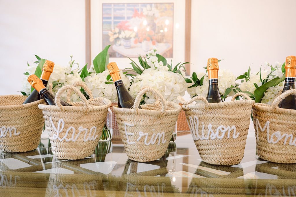 Detail shot of wedding party baskets with small Champaign bottles inside with white bouquets