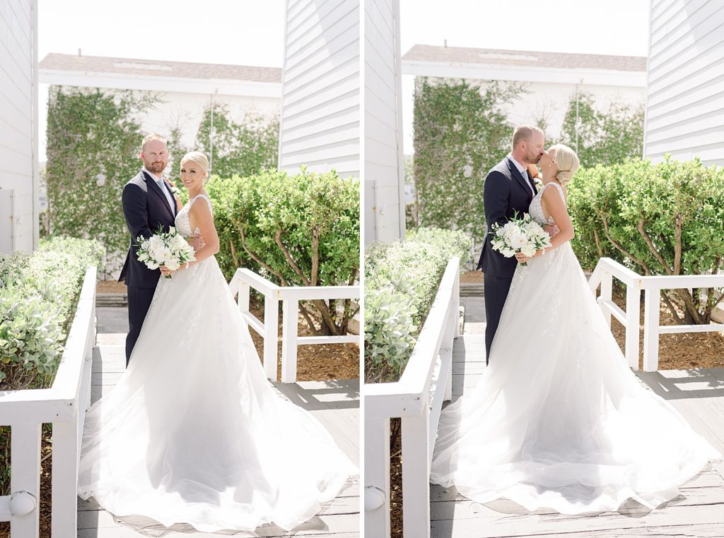 Formal portraits of Bride and Groom outside by green bushes kissing