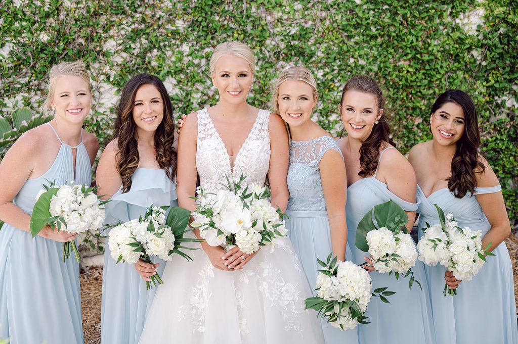 Bride with Bridesmaids holding white bouquets together