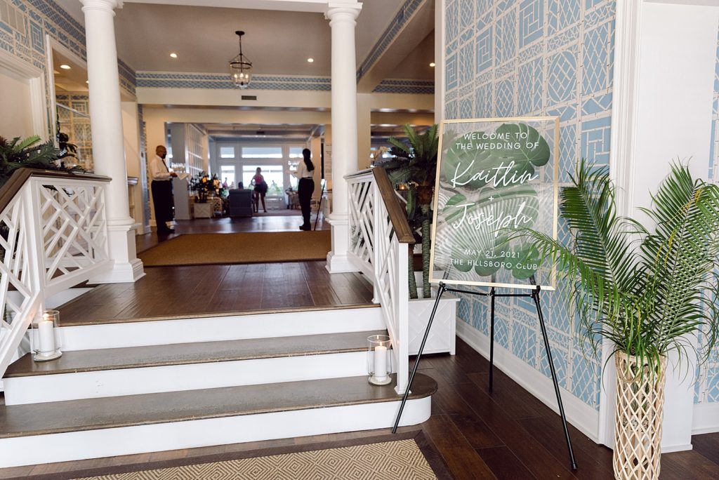 Detail shot of welcome sign with palm leafs for Reception